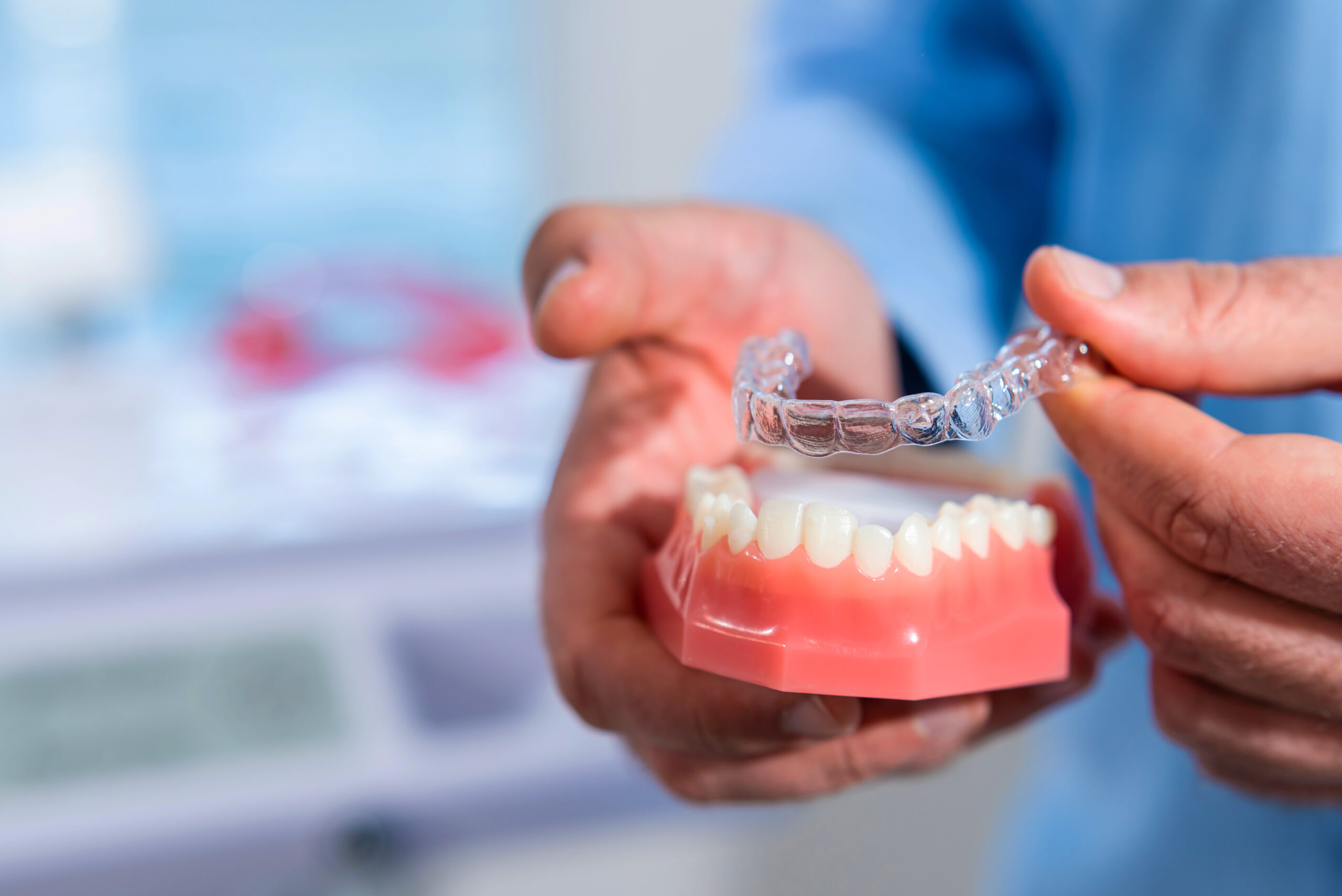 The dentist puts invisalign braces on the teeth of the artificial jaw in Rosemary Heights Family Dental