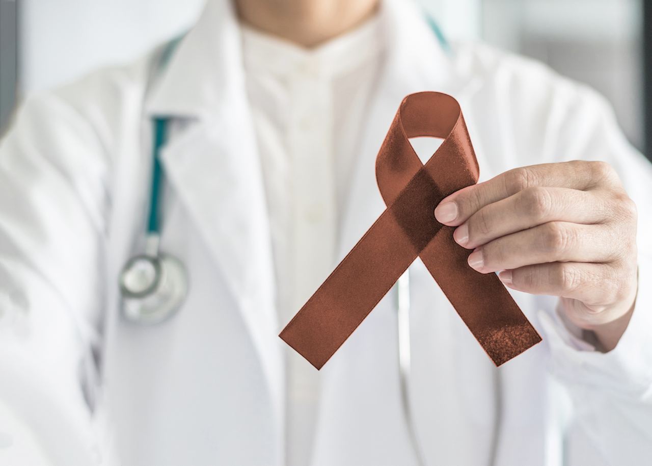 Copper Brown Awareness Ribbon on doctor’s hand, symbolic color for Anti-Tobacco, Colon Colorectal Cancers