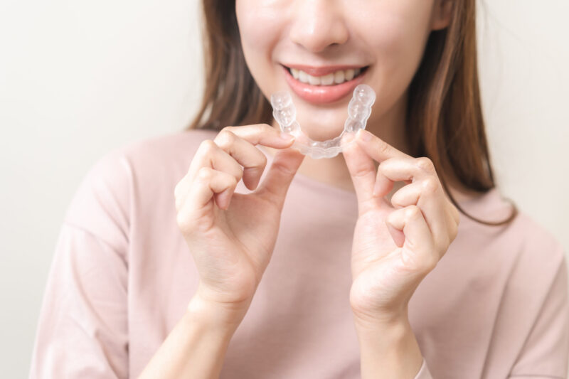 woman holding invisalign braces in South Surrey Rosemary dental center